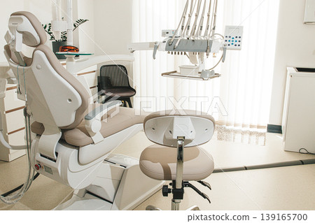 Modern dental clinic interior with equipment and patient chair ready for treatment Modern dental clinic interior with equipment and patient chair ready for treatment 139165700