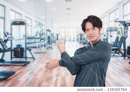 一位年輕男子正在健身房運動。 139165764