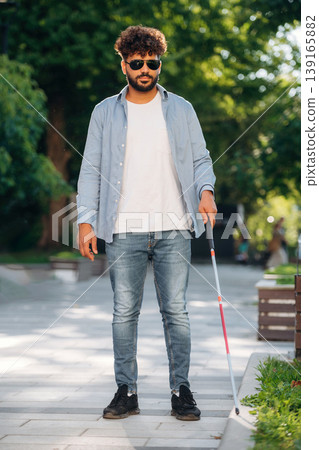 Using cane stick. Blind man in sunglasses is in the city Using cane stick. Blind man in sunglasses is in the city 139165882