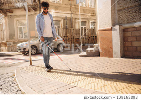 Eyewear and white cane. Blind man is walking in the city Eyewear and white cane. Blind man is walking in the city 139165898