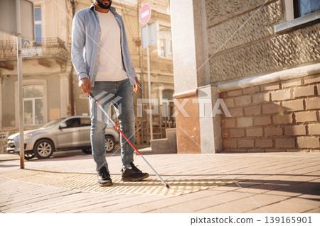 Walking on the pavement. A blind man with white cane is in the city Walking on the pavement. A blind man with white cane is in the city 139165901