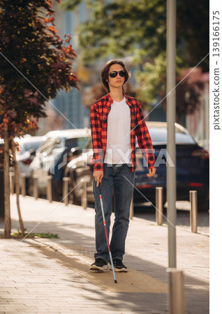 Blind young guy is in the town outdoors Blind young guy is in the town outdoors 139166175