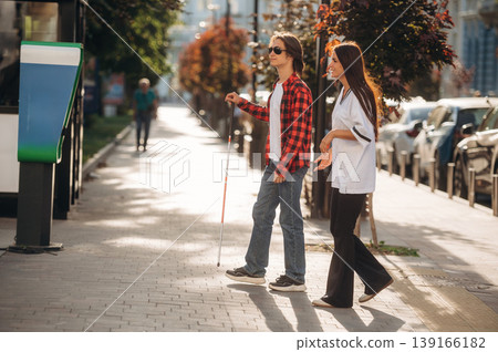 Woman is helping blind guy cross the road Woman is helping blind guy cross the road 139166182