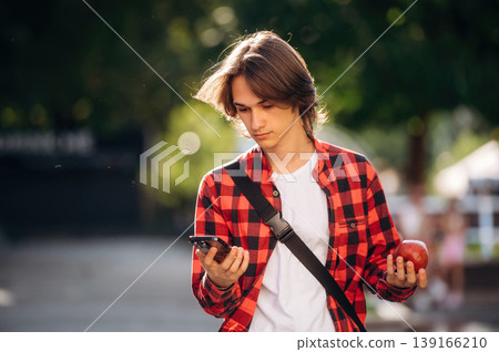 At sunny daytime. Young student is having a walk in the town 139166210