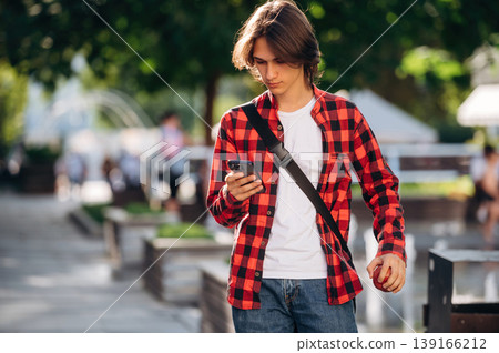 At sunny daytime. Young student is having a walk in the town 139166212