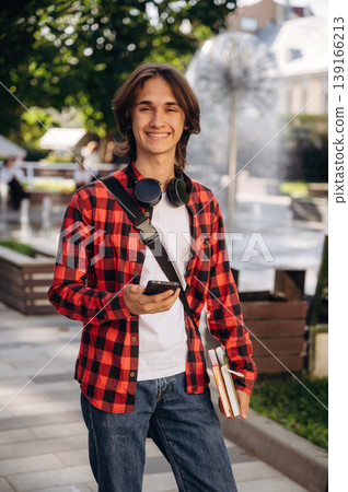 Wireless headphones on the neck. Young student is having a walk in the town 139166213
