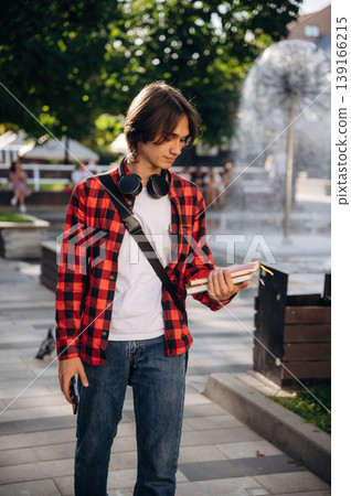 Wireless headphones on the neck. Young student is having a walk in the town 139166215