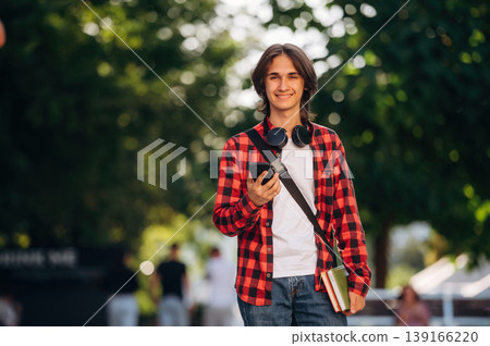 Wireless headphones on the neck. Young student is having a walk in the town 139166220