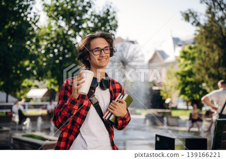 Wireless headphones on the neck. Young student is having a walk in the town 139166221
