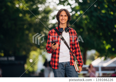 Feeling good, walking. Young student is outdoors at daytime Feeling good, walking. Young student is outdoors at daytime 139166226