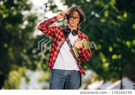 Having glasses on. Young student is having a walk in the town Having glasses on. Young student is having a walk in the town 139166248