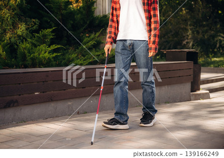 Particle view of blind man going with white cane outdoors Particle view of blind man going with white cane outdoors 139166249