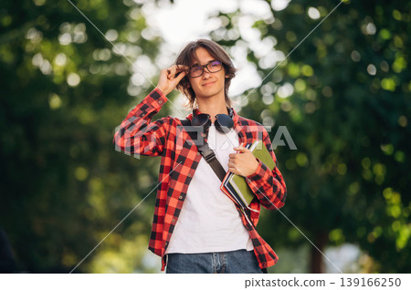 Having glasses on. Young student is having a walk in the town Having glasses on. Young student is having a walk in the town 139166250