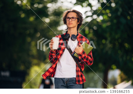 Smart, in glasses. Young student is having a walk in the town Smart, in glasses. Young student is having a walk in the town 139166255