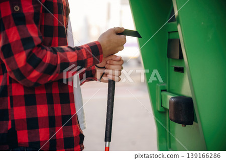 Close up view of man with white cane by the ATM using credit card Close up view of man with white cane by the ATM using credit card 139166286