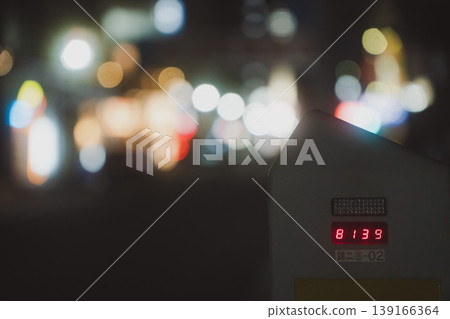 在夜晚的城市街角,一個停車計時器在美麗的虛化光暈映襯下顯得格外醒目。 在夜晚的城市街角,一個停車計時器在美麗的虛化光暈映襯下顯得格外醒目。 139166364
