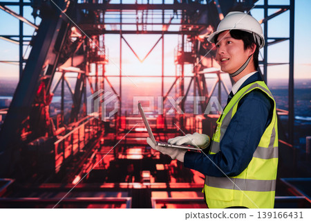 一名男子正在摩天大樓的建築工地工作。 一名男子正在摩天大樓的建築工地工作。 139166431