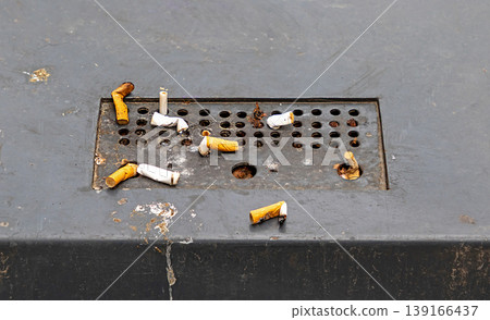Cigarette butt in ashtray on street 139166437