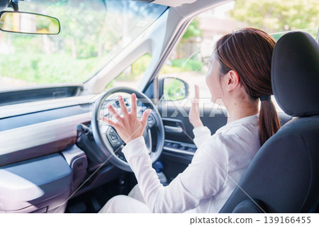 A woman driving a self-driving car hands-free. A woman driving a self-driving car hands-free. 139166455