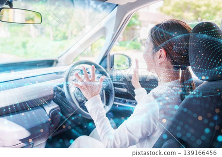 A woman driving a self-driving car hands-free. 139166456