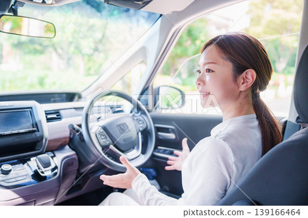 A woman driving a self-driving car hands-free. A woman driving a self-driving car hands-free. 139166464