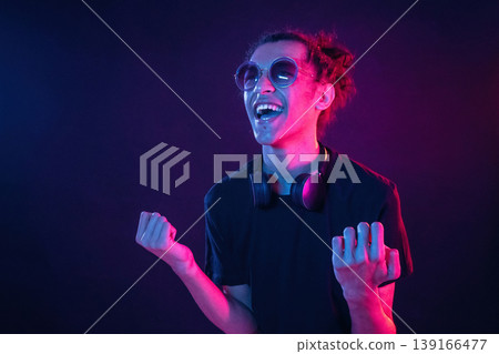Guy is indoors at night with neon lighting Guy is indoors at night with neon lighting 139166477