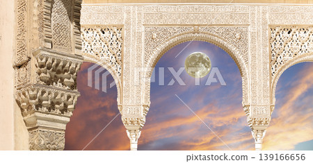 Arches in Islamic (Moorish) style (against the sunset with the super moon) in Alhambra, Granada, Spain Arches in Islamic (Moorish) style (against the sunset with the super moon) in Alhambra, Granada, Spain 139166656
