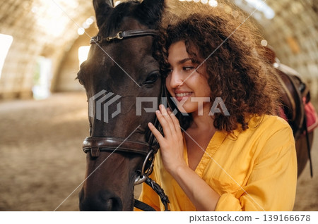 Love and care conception. Beautiful young woman is with horse in hangar Love and care conception. Beautiful young woman is with horse in hangar 139166678