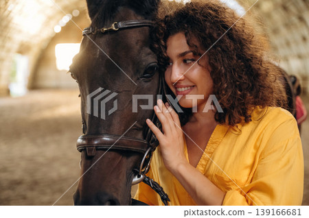 Feeling good, taking care of animal. Beautiful young woman is with horse in hangar 139166681