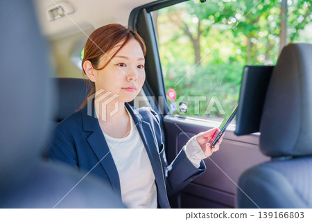 A career woman gets into a taxi with a smile. A career woman gets into a taxi with a smile. 139166803