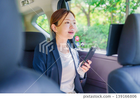 A career woman gets into a taxi with a smile. 139166806
