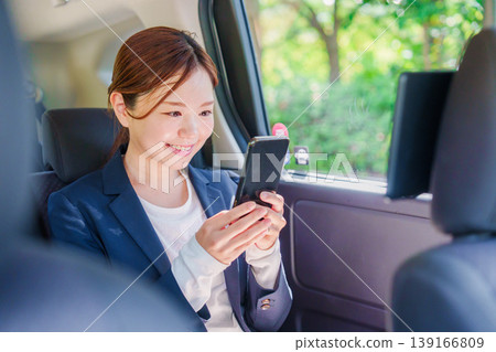 一位職業婦女微笑著坐進計程車。 一位職業婦女微笑著坐進計程車。 139166809