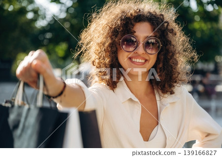 Happy woman is with shopping bags in town 139166827
