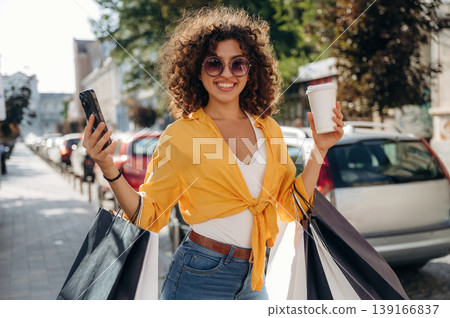 Wellbeing and leisure conception. Happy woman is with shopping bags in town 139166837