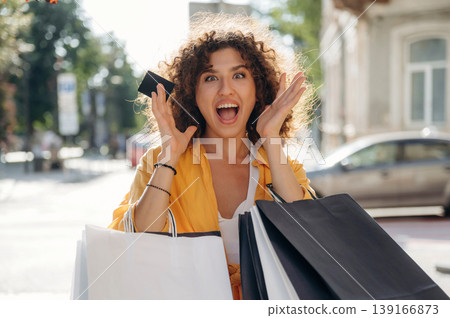 Ready to use the credit card. Happy woman is with shopping bags in town Ready to use the credit card. Happy woman is with shopping bags in town 139166873