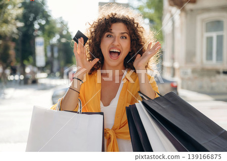 Ready to use the credit card. Happy woman is with shopping bags in town Ready to use the credit card. Happy woman is with shopping bags in town 139166875