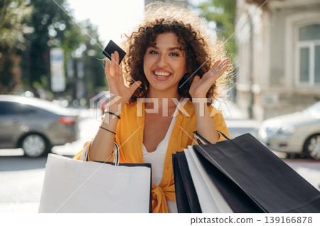 Ready to use the credit card. Happy woman is with shopping bags in town Ready to use the credit card. Happy woman is with shopping bags in town 139166878