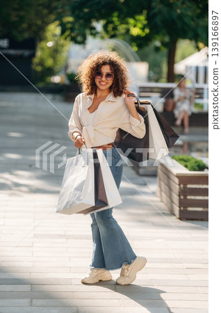 Model is standing and posing. Happy woman is with shopping bags in town 139166897