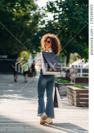Weekend activities conception. Happy woman is with shopping bags in town Weekend activities conception. Happy woman is with shopping bags in town 139166905