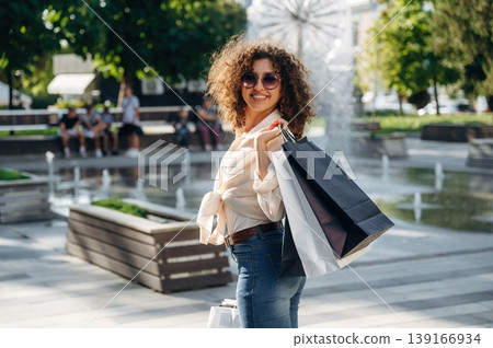 Standing and smiling. Happy woman is with shopping bags in town Standing and smiling. Happy woman is with shopping bags in town 139166934
