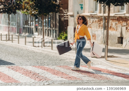 In blue jeans. Happy woman is with shopping bags in town 139166969
