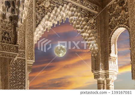 Arches in Islamic (Moorish) style (against the sunset with the super moon) in Alhambra, Granada, Spain Arches in Islamic (Moorish) style (against the sunset with the super moon) in Alhambra, Granada, Spain 139167081