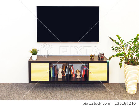 Large TV screen above wooden cabinet Large TV screen above wooden cabinet 139167210
