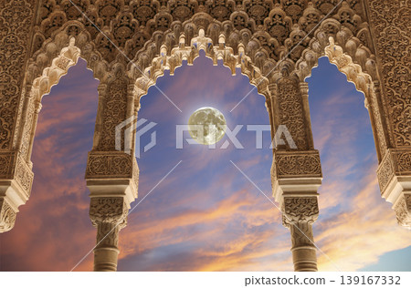 Arches in Islamic (Moorish) style (against the sunset with the super moon) in Alhambra, Granada, Spain Arches in Islamic (Moorish) style (against the sunset with the super moon) in Alhambra, Granada, Spain 139167332