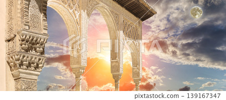 Arches in Islamic (Moorish) style (against the sunset with the super moon) in Alhambra, Granada, Spain Arches in Islamic (Moorish) style (against the sunset with the super moon) in Alhambra, Granada, Spain 139167347