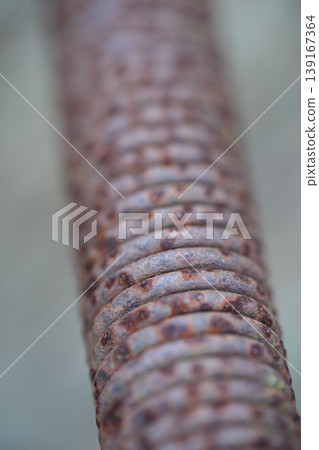 Close-up macro shot of rusty metal coil texture with weathered surface detail, abstract industrial element 139167364
