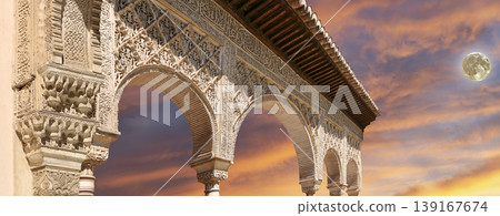 Arches in Islamic (Moorish) style (against the sunset with the super moon) in Alhambra, Granada, Spain Arches in Islamic (Moorish) style (against the sunset with the super moon) in Alhambra, Granada, Spain 139167674