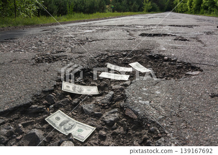 Dollar bills in the potholes on road Dollar bills in the potholes on road 139167692