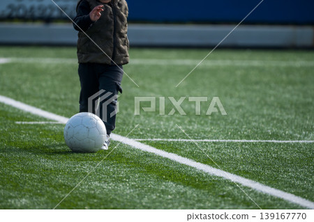 Child Playing Soccer On Turf Field Child Playing Soccer On Turf Field 139167770