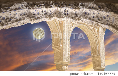 Arches in Islamic (Moorish) style (against the sunset with the super moon) in Alhambra, Granada, Spain Arches in Islamic (Moorish) style (against the sunset with the super moon) in Alhambra, Granada, Spain 139167775